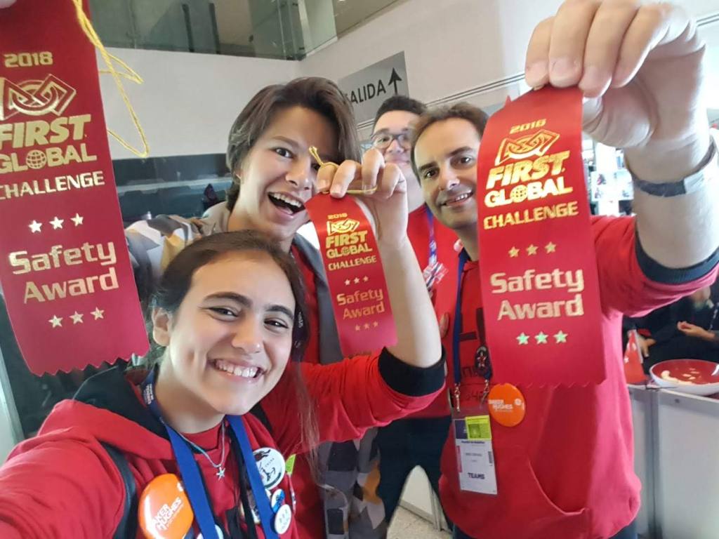 Four team members holding FIRST Global Challenge awards.