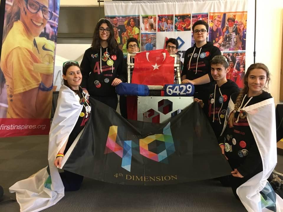 Team members gathered around a 6429 team flag at an event.